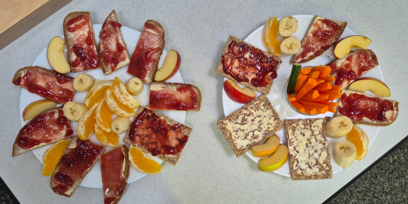 Zwei schön gestaltete Brotzeitteller mit belegten Broten und Rohkost.